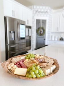 charcuterie board on kitchen counter with baked brie cheese 